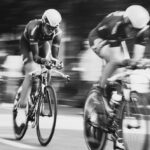 Three road cyclists ride closely together in a fast-moving paceline