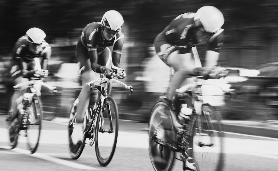 Three road cyclists ride closely together in a fast-moving paceline